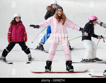 Stacey Solomon (centre), who took part in The Jump, launches the inaugural National Schools Snowsport Week, with pupils from the Larmenier and Sacred Heart Catholic Primary School, at The Snow Centre in Hemel Hempstead, Hertfordshire. Stock Photo