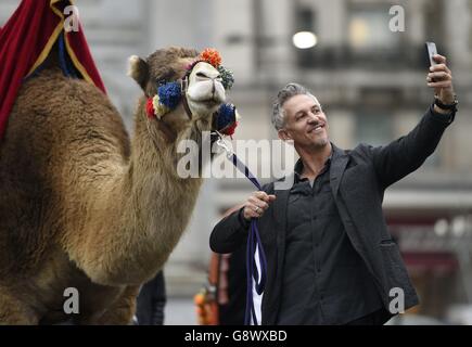 Gary Lineker takes a selfie with a camel as he brings Thailand, Morocco, India and New York to Marble Arch, London, for the launch of Walkers Spell & Go campaign, where people collect letters in packs of crisps to be in with a chance of winning one of 20,000 holidays up for grabs. Stock Photo