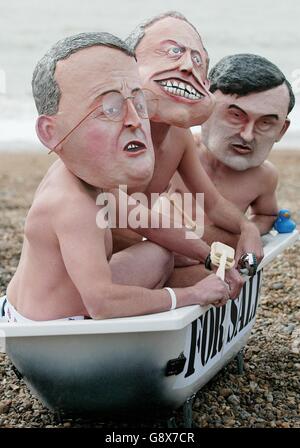 Three campaigners from the World Development wearing Movement wearing masks depicting Gordon Brown, Hilary Benn and Tony Blair take a bath on Brighton beach, to highlight the misuse of Britain's aid budget to promote water privatisation in the Third World following the speech by The Secretary of State for International Development, Hilary Benn to the Labour Conference. Stock Photo