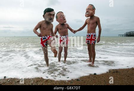 Three campaigners from the World Development wearing Movement wearing masks depicting Gordon Brown, Hilary Benn and Tony Blair take a bath on Brighton beach, to highlight the misuse of Britain's aid budget to promote water privatisation in the Third World following the speech by The Secretary of State for International Development, Hilary Benn to the Labour Conference. Stock Photo