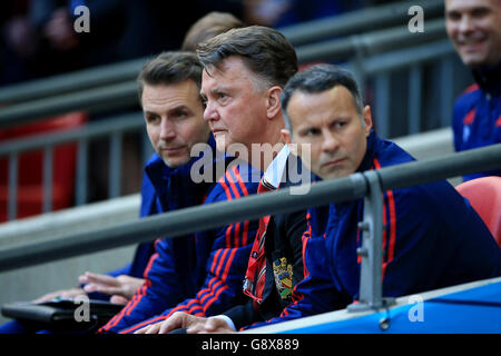 Manchester United manager Louis van Gaal (centre), assistant manager Ryan Giggs (right) and assistant coach Albert Stuivenberg (left) during the Emirates FA Cup, Semi-Final match at Wembley Stadium, London. Stock Photo