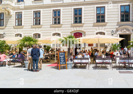 People on outdoor terrace of Hofburg cafe in inner castle court In der burg in downtown Vienna, Austria Stock Photo