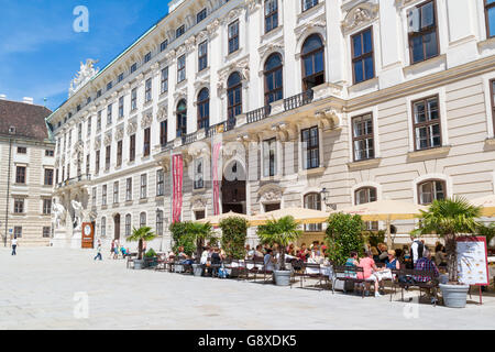 Inner castle court with people on outdoor terrace of cafe and Sisi museum, Hofburg Palace, Vienna, Austria Stock Photo