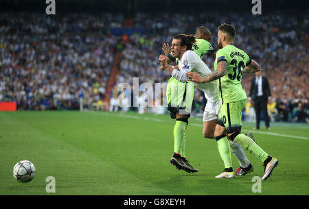 Real Madrid's Gareth Bale (centre) in action with Manchester City's Nicolas Otamendi (right) and Fernandinho during the UEFA Champions League Semi Final, Second Leg match at the Santiago Bernabeu, Madrid. Stock Photo