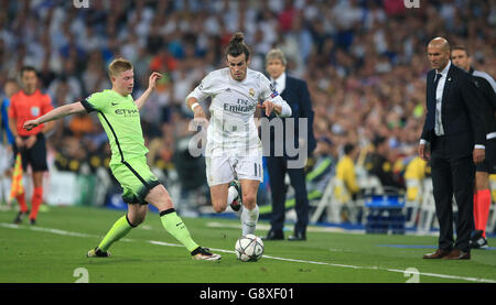 Manchester City's Kevin De Bruyne (left) and Real Madrid's Gareth Bale in action as Real Madrid manager Zinedine Zidane looks on during the UEFA Champions League Semi Final, Second Leg match at the Santiago Bernabeu, Madrid. Stock Photo