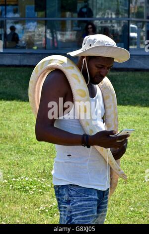 A man with a large python over his shoulders walking around the ...