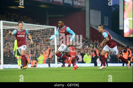 West Ham United's Diafra Sakho (centre) celebrates scoring his side's first goal of the game alongside teammates Mark Noble (left) and Manuel Lanzani during the Barclays Premier League match at Upton Park, London. Stock Photo