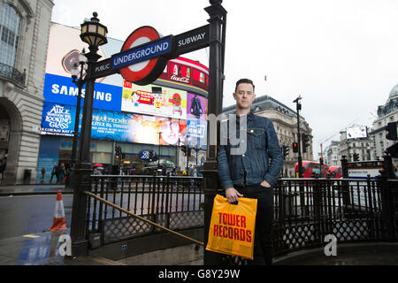 Colin Hanks holding a Tower Records bag at Piccadilly Circus in London, the star of The Good Guys and Fargo, makes his directorial debut with All Things Must Pass, a film that tells the story of Tower Records and features Sir Elton, Foo Fighters frontman Dave Grohl and singer Bruce Springsteen. Stock Photo
