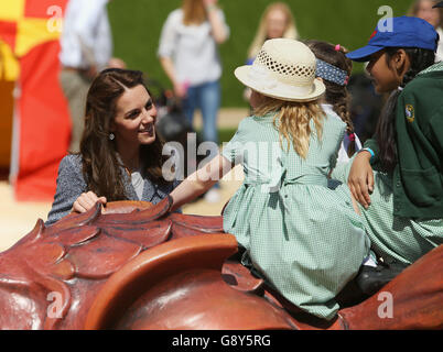 The Duchess of Cambridge meets children as she views Hampton Court's recently unveiled Magic Garden, marking the official opening of the palace's new children's play area. Stock Photo