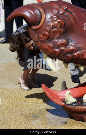 The Duchess of Cambridge looks inside the mouth of a dragon as she views Hampton Court's recently unveiled Magic Garden, marking the official opening of the palace's new children's play area. Stock Photo