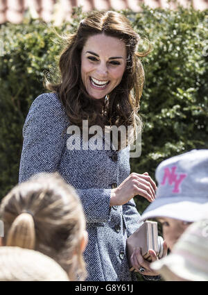 The Duchess of Cambridge meets children as she views Hampton Court's recently unveiled Magic Garden, marking the official opening of the palace's new children's play area. Stock Photo