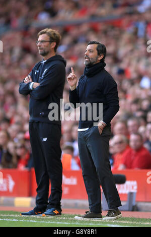 Liverpool manager Jurgen Klopp (left) and Watford manager Quique Sanchez Flores on the touchline during the Barclays Premier League match at Anfield, Liverpool. Stock Photo