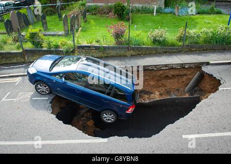 A car which has partially disappeared down a sinkhole in Woodland Terrace in Greenwich, south-east London.