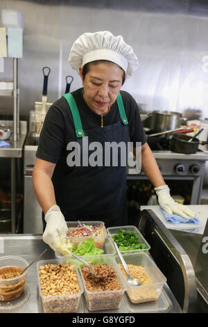 Asian woman chef preparing food in kitchen Stock Photo