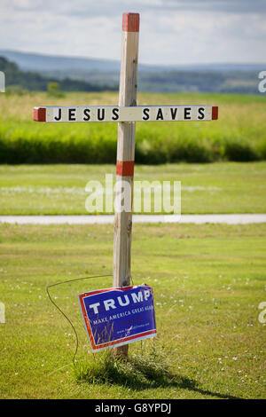 New York State, USA, June 29, 2016: A rural evangelical voter places a Trump sign on a 'Jesus Saves' crucifix in the front yard. Trump's popularity among evangelicals helped him to dominate the Republican primary vote. Credit:  Philip Scalia/Alamy Live News Stock Photo