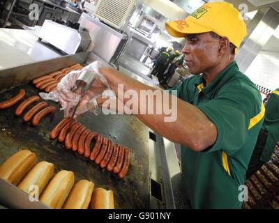 New York, US. 29th June, 2016. An employee preparing Hot Dogs at 'Nathan's' restaurant in Coney Island in New York, US, 29 June 2016. The restaurant famous for simple fast food snack celebrates its 100th anniversary this year. PHOTO: JOHANNES SCHMITT-TEGGE/dpa/Alamy Live News Stock Photo