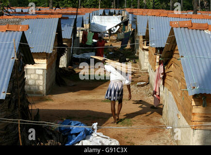 A person carries timber through a transitional camp in Salli, in the Trincomalee District in eastern Sri Lanka, on Saturday December 3, 2005. Tsunami victims are awaiting permanent homes to be built, after their homes were destroyed during the disaster. The quality and rate of reconstruction in post-tsunami Sri Lanka has been far lower than expected despite ample funds, aid agencies have conceded. See PA Story DEATH Quake Reconstruction. PRESS ASSOCIATION Photo. Photo credit should read: Chris Young/PA Stock Photo