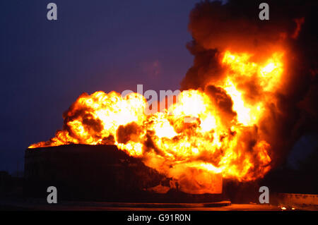 Flames rise from one of the fuel tanks Monday December 12, 2005, at the Buncefield oil depot near Hemel Hemsptead which started early Sunday morning. Firefighters spent yesterday containing the blaze with a 'water curtain' between the raging flames and the seven unexploded fuel tanks and have now gathered enough equipment from around the country to smother the fire with foam. See PA story BLAST Explosion. PRESS ASSOCIATION Photo. Photo credit should read: Mike Seaman/ PA. Stock Photo