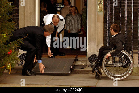 Britain's Prime Minister Tony Blair helps position a wheelchair ramp for Michael Taylor, 17, from Crewe, when he and several other children handed a letter to the Mr Blair calling for action against child poverty, Wednesday December 21, 2005. Members of the Child Poverty Action Group (CPAG) met Tony Blair on the steps of Number 10 exactly 40 years after the group first urged Harold Wilson to take action to improve standards of living for the poorest families. See PA Story POLITICS Poverty. PRESS ASSOCIATION Photo. Photo credit should read: John Stillwell/PA Stock Photo