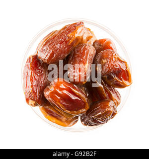 Dried dates in bowl, isolated on white and viewed from above. Stock Photo