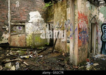 Graffiti and vandalism in abandoned derelict industrial building. Stock Photo