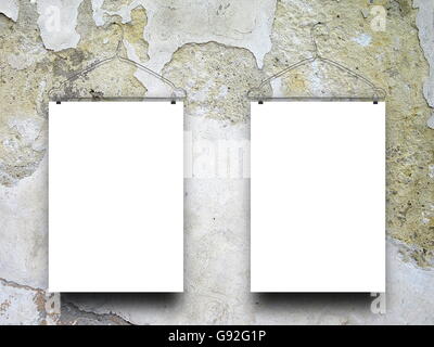Close-up of two square blank frames hanged by clothes hanger against weathered scratched concrete wall background Stock Photo