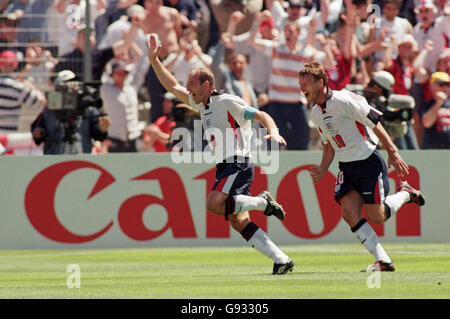 Alan Shearer of England (left) celebrates scoring the opening goal with teammate Teddy Sheringham (right) Stock Photo