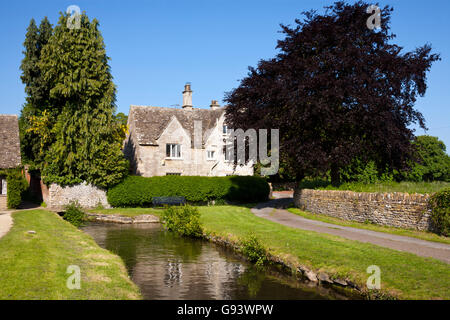 The infant River Thames passes idyllic Cotswold cottages in Ashton Keynes, Wiltshire, UK Stock Photo