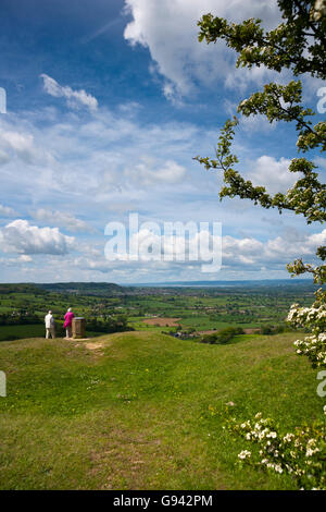 Two people at Coaley Peak viewpoint, the view over The Severn Vale from the Cotswold escarpment near Nympsfield, Gloucestershire, UK Stock Photo