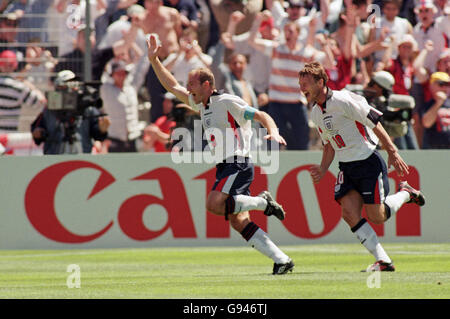Soccer - World Cup France 98 - Group G - England v Tunisia. Alan Shearer of England (left) celebrates scoring the opening goal with teammate Teddy Sheringham (right) Stock Photo