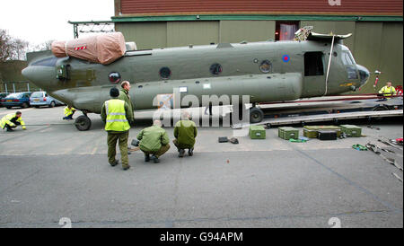 Ground crew ease an RAF Chinook helicopter from 18 Squadron onto a low loader while the helicopter crew watch at RAF Odiham in Hampshire, Tuesday February 7, 2006. Three of the heavy lift helicopters are preparing to ship out to Afghanistan today as the UK continues its build up of military forces in the war-torn country. The choppers will be flown from Odiham by C-17 transports to the Helmand region of the country where they will assist Royal Engineers to build a base in the area. See PA story DEFENCE Afghanistan. PRESS ASSOCIATION photo. Photo credit should read: Chris Ison/PA. Stock Photo