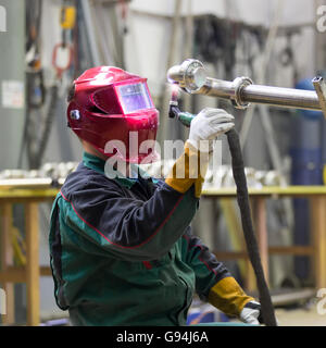 Industrial worker welding in metal factory. Stock Photo