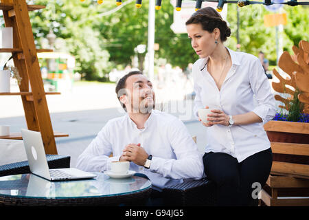 Business Team man and woman at Cafe having a conversation using laptop. Working Meeting Concept Stock Photo