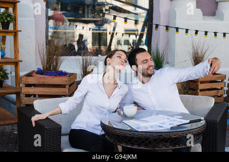 Happy business couple taking selfie at outdoor restaurant Stock Photo