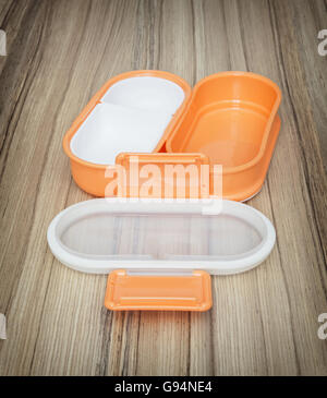 Orange folding plastic box for food storage on the wooden background. Open box. Kitchen equipment. Set of boxes. Stock Photo