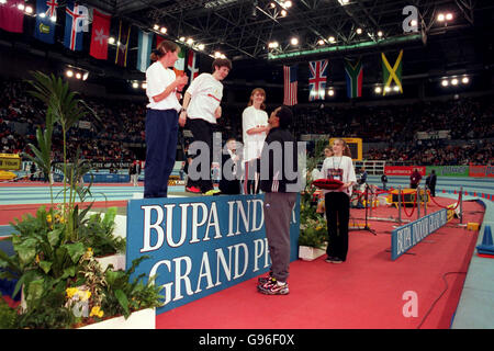 Athletics - BUPA Indoor Grand Prix - Birmingham. Lucy Thomas of Neath (centre) climbs onto the podium for the presentation in the McDonald's Young Athletes' League Under15 1000m Stock Photo