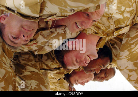 Members of the 1st Battalion Royal Scots triumphant rugby union team including team-captain, Captain Rob Muir (top, centre-right), from Edinburgh, Captain Kevin Gartside (middle, centre-right), from Belfast, Private Tuicaucau (2nd right) and Private Tawakenou (right), both from Fiji, form a scrum with other members of their regiment at Shaibah Logistics Base (SLB) near Basra, southern Iraq. Stock Photo