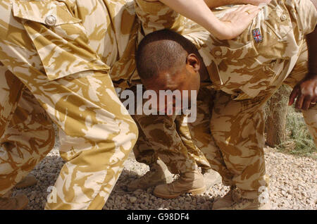 Members of the 1st Battalion Royal Scots triumphant rugby union team including Private Tawakenou (right), from Fiji, forms a scrum with other members of his team and regiment at Shaibah Logistics Base (SLB) near Basra, southern Iraq, Saturday March 18, 2006. The team recently defeated the Royal Welsh in the final of the Army Cup. See PA story DEFENCE Iraq. PRESS ASSOCIATION photo. Photo Credit should read : Johnny Green/PA. Stock Photo