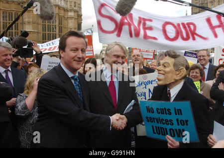 Conservative Party leader David Cameron shakes hands with a man wearing a Tony Blair mask as he addresses a demonstration by hospital workers and patients against hospital closures opposite the Houses of Parliament in central London, Tuesday March 28, 2006. Watch for PA story. PRESS ASSOCIATION photo. Photo credit should read: Johnny Green/PA Stock Photo