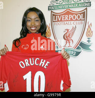 Footballers' Wives actress Phina Oruche holds up a shirt signed by Liverpool Football Club players during a visit to the club's Melwood training ground Thursday April 6, 2006, ahead of this month's Flora London Marathon in which she will be competing to raise money for the Anthony Nolan Trust. A Liverpool FC fan since childhood, Phina, who has recently returned from LA to the UK to star in The Bill and Footballers' Wives, started her film and TV career in the United States and has starred in 'Nip/Tuck' and 'Buffy the Vampire Slayer'. Stock Photo