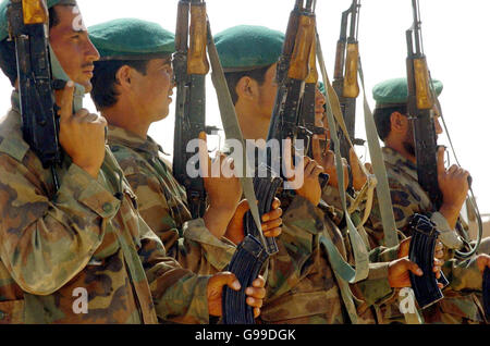 Soldiers from the Afghan National Army go through their paces in front of the watching eyes of British Defence Secretary John Reid and their British Army training instructors at Camp Bastion in southern Afghanistan. Stock Photo