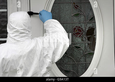 A member of a Gardai forensic team examines the house on Ratoath Avenue, Finglas, where 30-year-old Dublin man Lee Kinsella was shot dead last night. Stock Photo