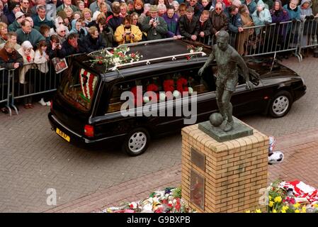 The funeral procession makes its way to the church past a statue of Sir Stanley Matthews Stock Photo