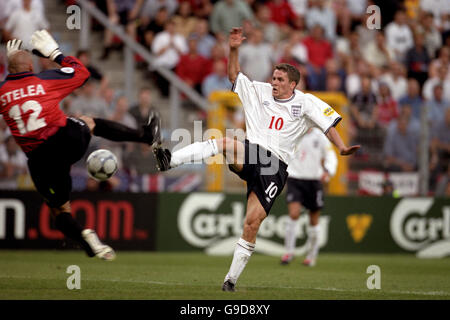 England's Michael Owen (r) touches the ball past Romania goalkeeper Bogdan Stelea (l) before slotting the ball into the empty net to give England the lead Stock Photo