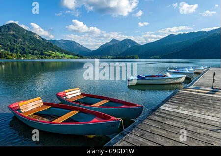 Rowing boats and electric boats at jetty, Schliersee, Markt Schliersee, mountains Brecherspitz and Spitzingsattel Stock Photo
