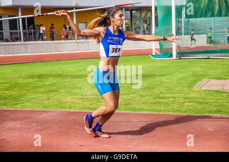 young woman throwing javelin on an athletic piste Stock Photo