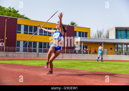 young woman throwing javelin on an athletic piste Stock Photo