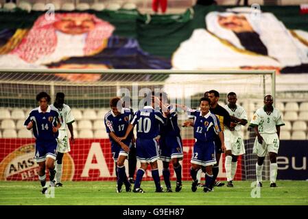 Japan celebrate the second goal in their 4-1 victory over Saudi Arabia with a Saudi Flag with Prince Sultan bin Fahad and Prince Fisul bin Fahad behind the goal Stock Photo