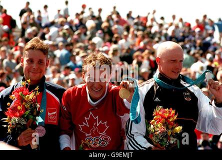 The triathlon medal winners (L-R) Czech Republic's Jan Rehula, Bronze, Canada's Simon Whitfield, Gold, and Germany's Stephan Vuckovic, Silver celebrate outside the Sydney Opera House Stock Photo