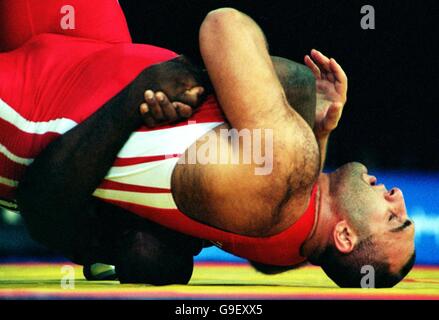 The Ukraine's Georgiy Saldadze (red) is slammed to the floor by Cuba's Hector Milian (blue, hidden) Stock Photo